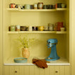 Kitchen shelving with mugs, vase, kitchen aid, and whisk.