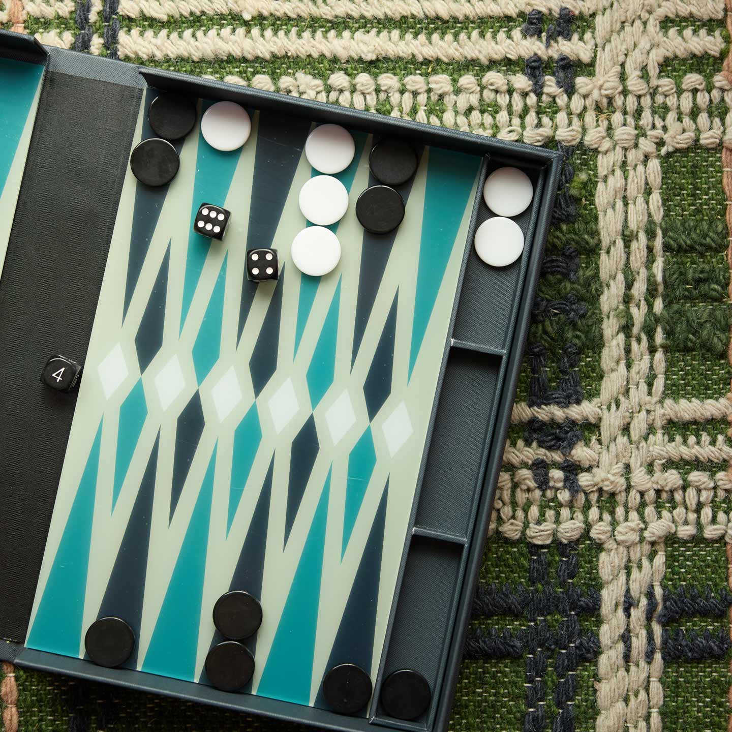 Backgammon game open on rug.