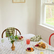 Spring tabletop setting with berries, pastries, eggs, and Essential Gingham Napkins in Olive.