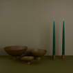 A trio of footed bowls and pair of candle holders, all in Olive, with green taper candles.