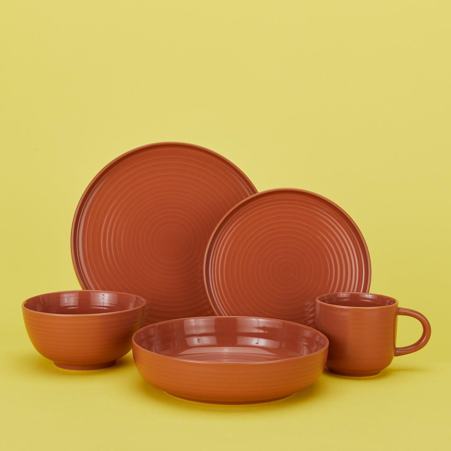 Esssential dinnerware set in terracotta with plates bowls and mug