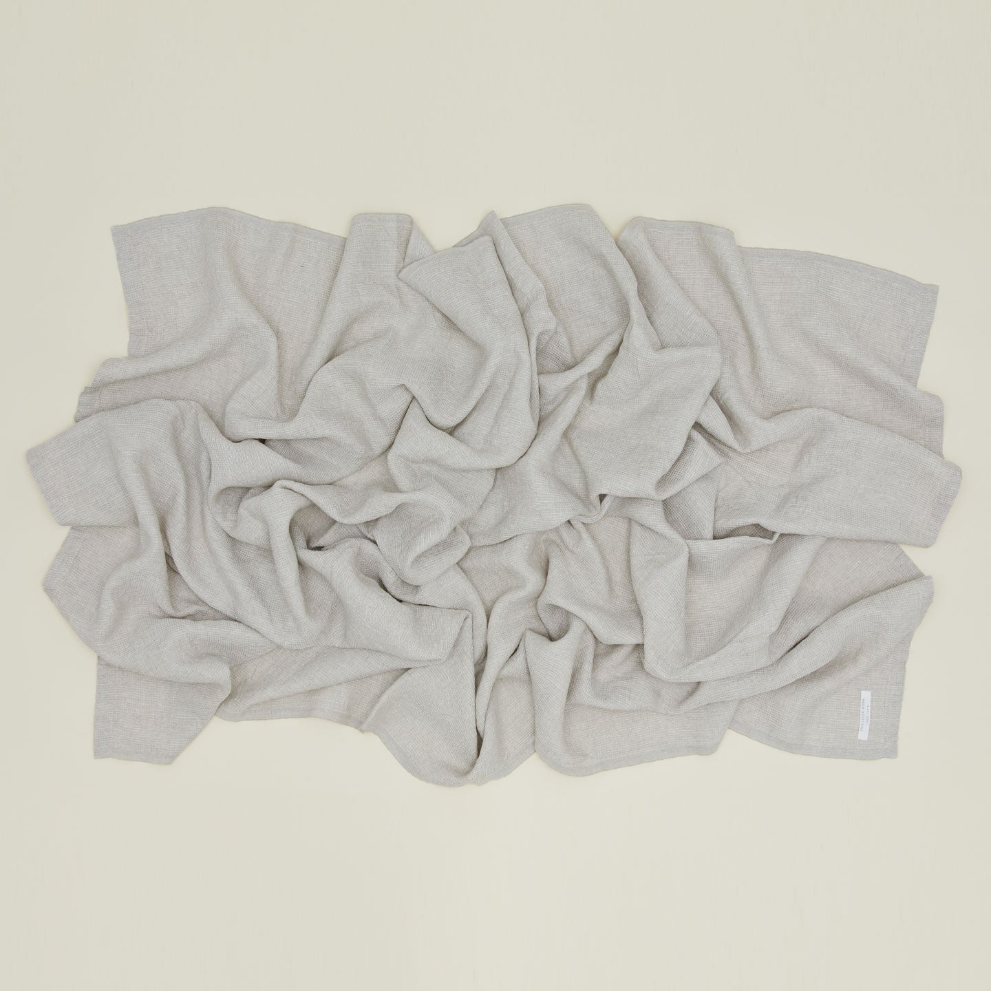 A Linen Washed Waffle Throw Blanket in natural.
