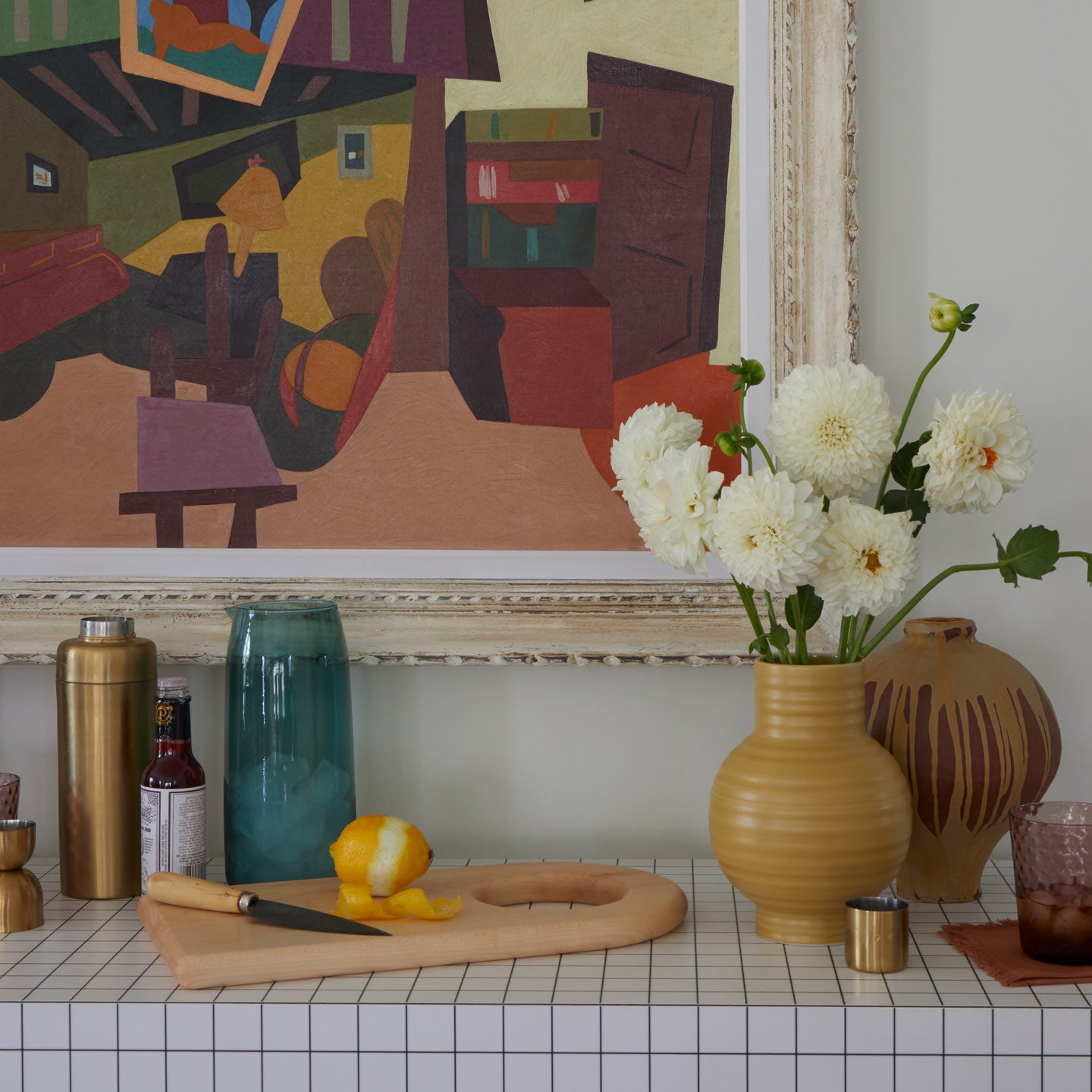 Bar setup with vases and flowers and painting in background