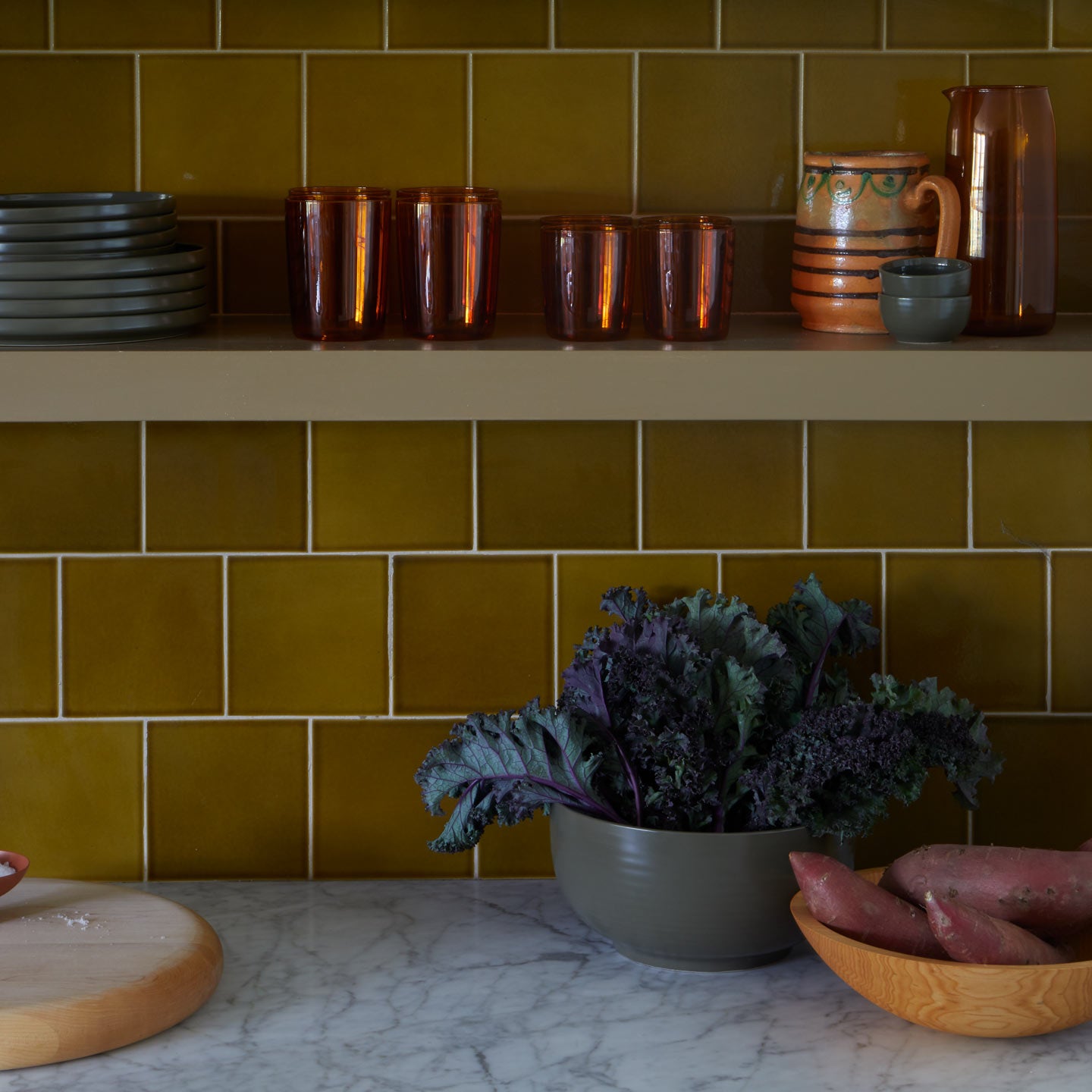 Kitchen shelves with bowls and produce and Essential Glassware in Terracotta and Essential Plates in Olive.