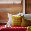 Window seat with pillows and espresso mugs.
