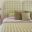 Bed with sage and lilac bedding and Essential Gingham Pillow in Olive.