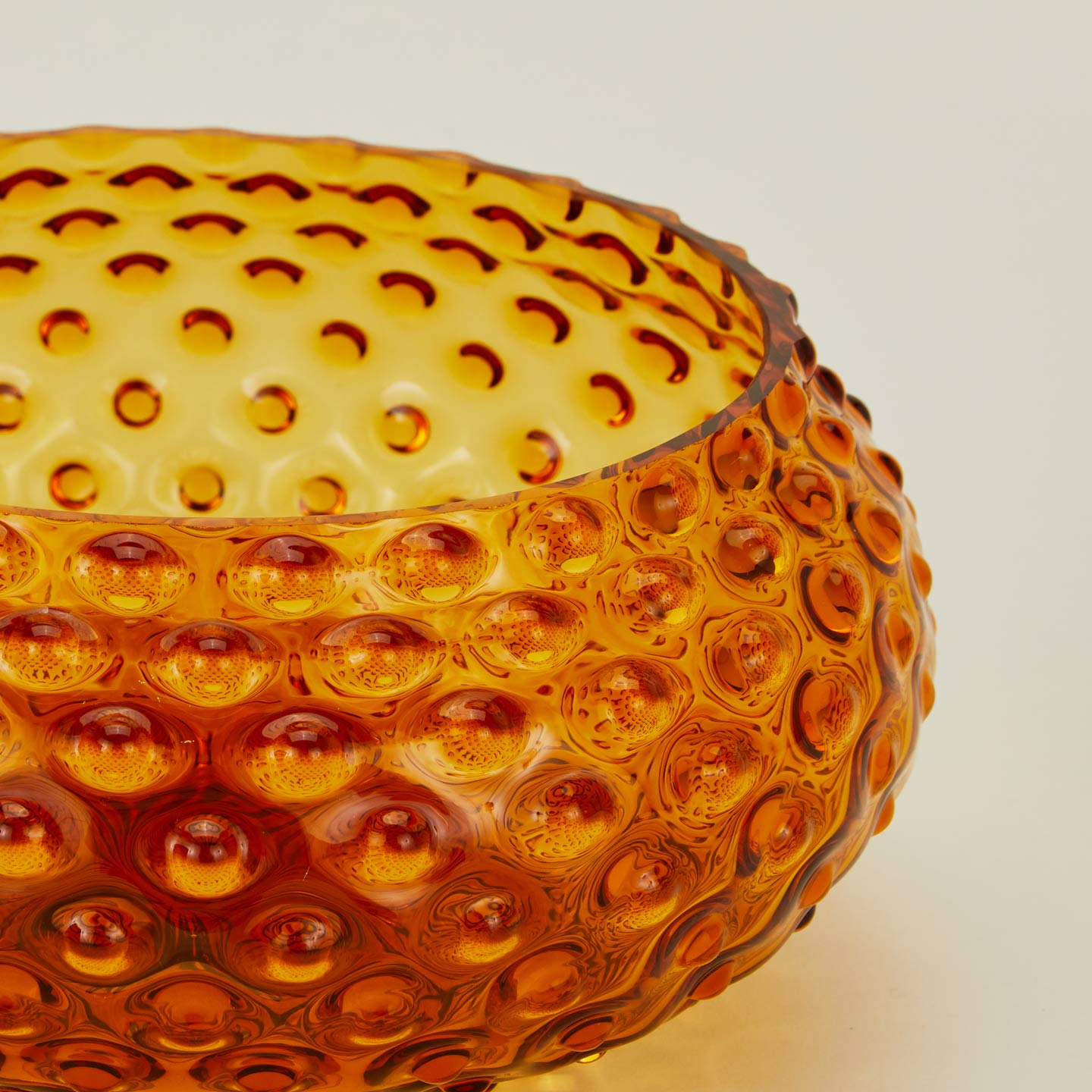 Close up of glass hobnail amber serving bowl.
