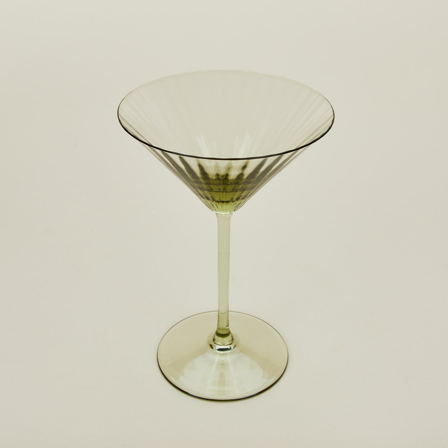 Three-quarter angle of ribbed olive martini glass.
