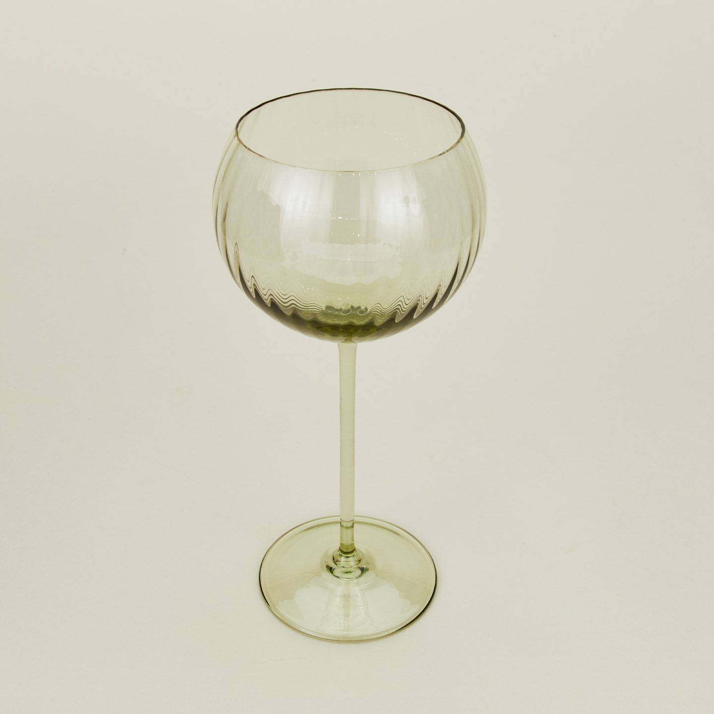 Three-quarter angle of ribbed olive wine glass.