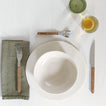 Placesetting with Atelier Dinnerware on white tablecloth.