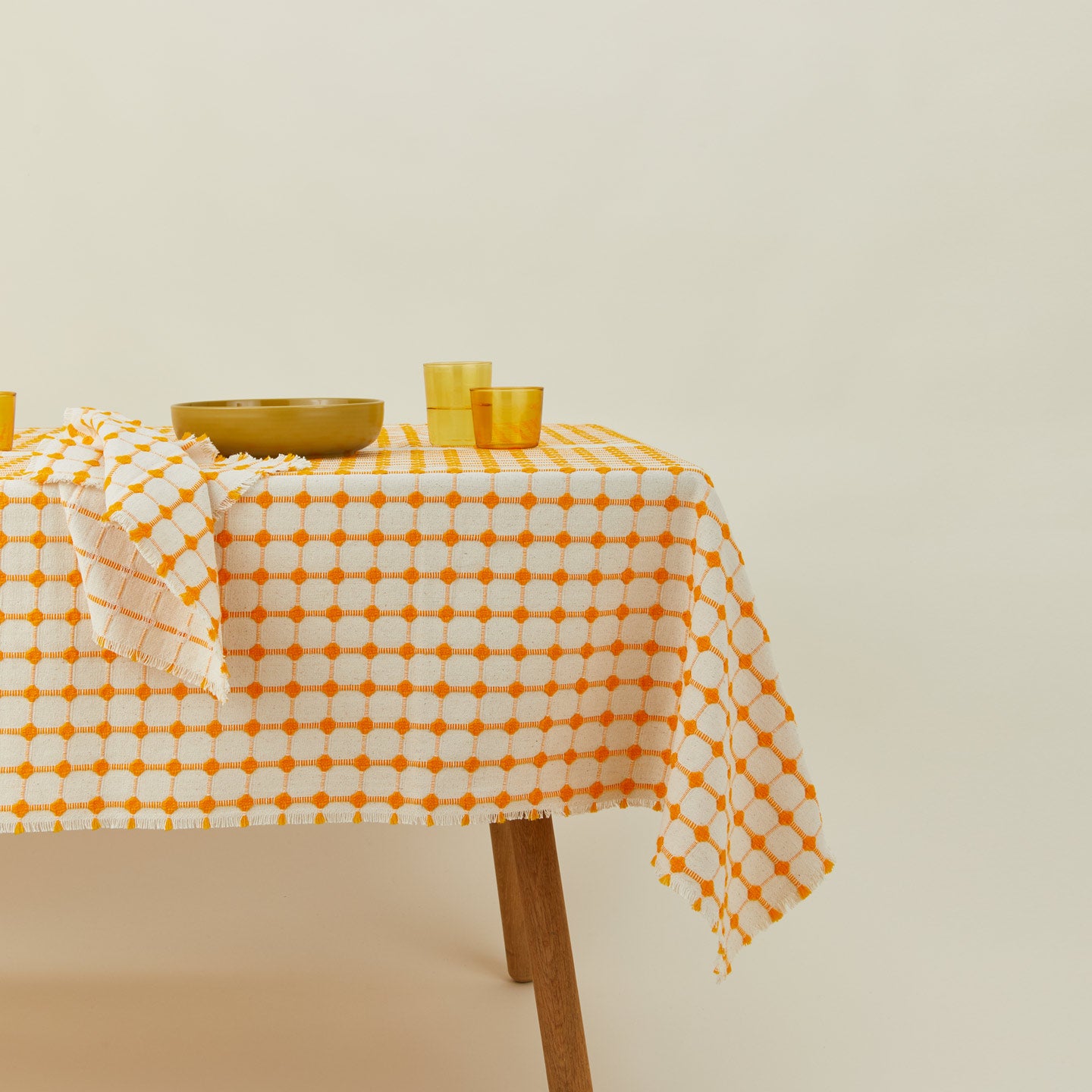 Dove and Donkey wicker fringed tablecloth in marigold with place setting
