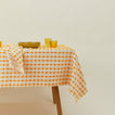 Dove and Donkey wicker fringed tablecloth in marigold with place setting