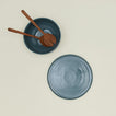 Overhead view of essential serveware set in peacock with wooden utensils