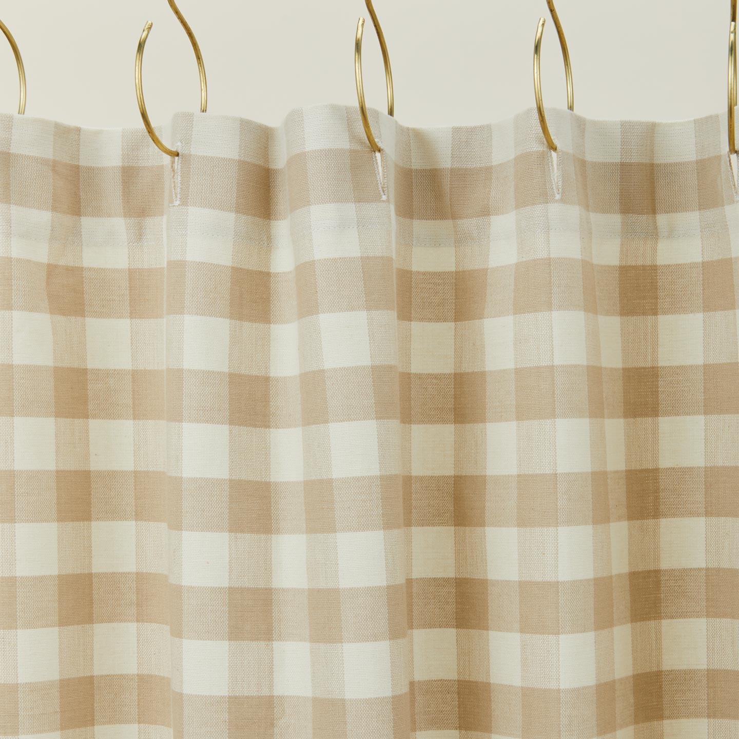 Gingham shower curtain in ivory/flax on gold curtain hooks