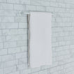 Essential towel bar in white on a tile background.