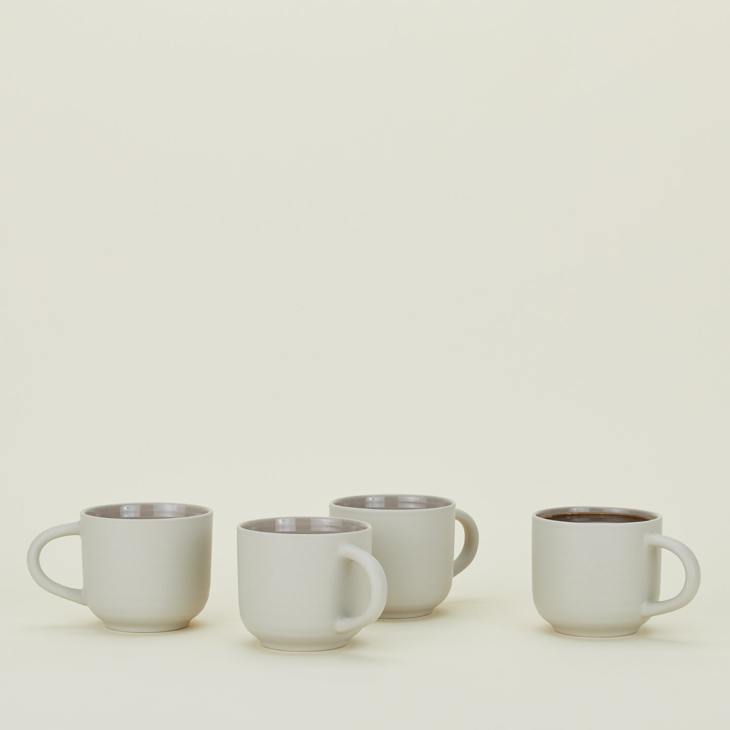 Four Essential Mugs in Light Grey, with coffee.