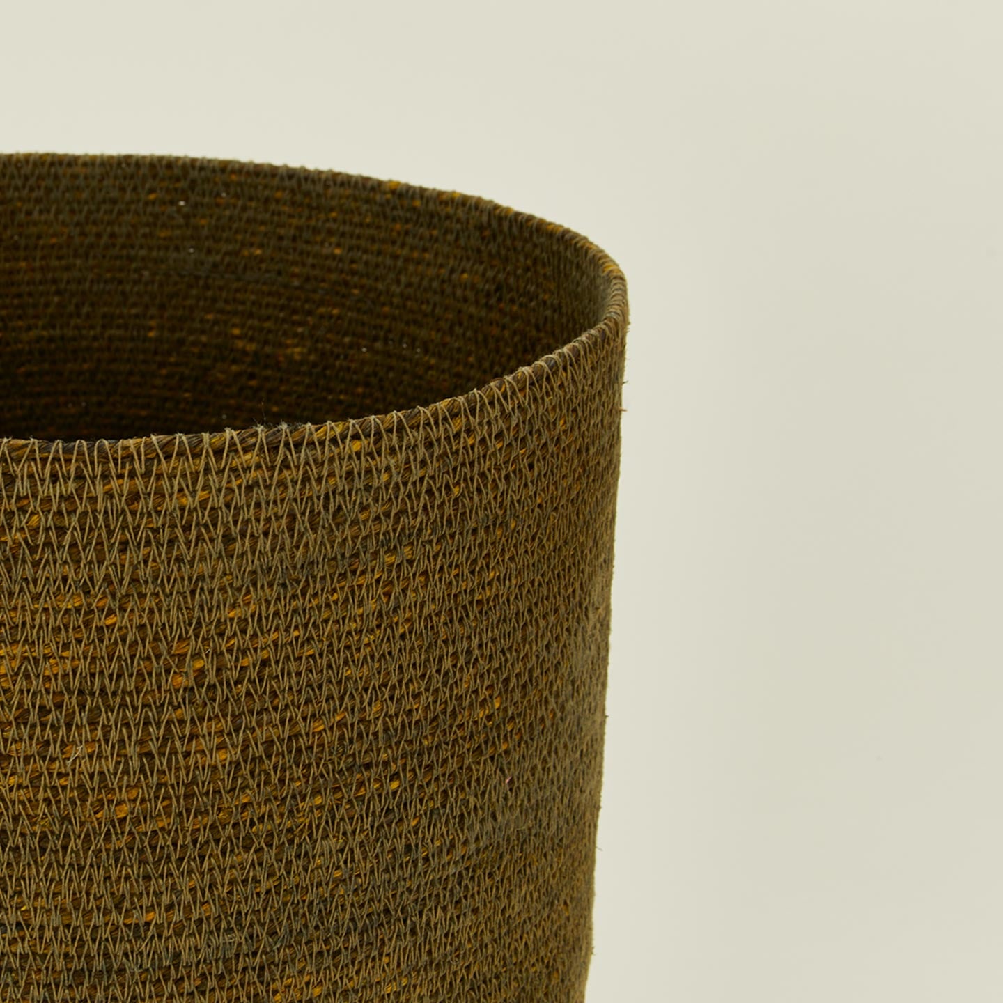 Close up view of essential woven wastebasket in olive