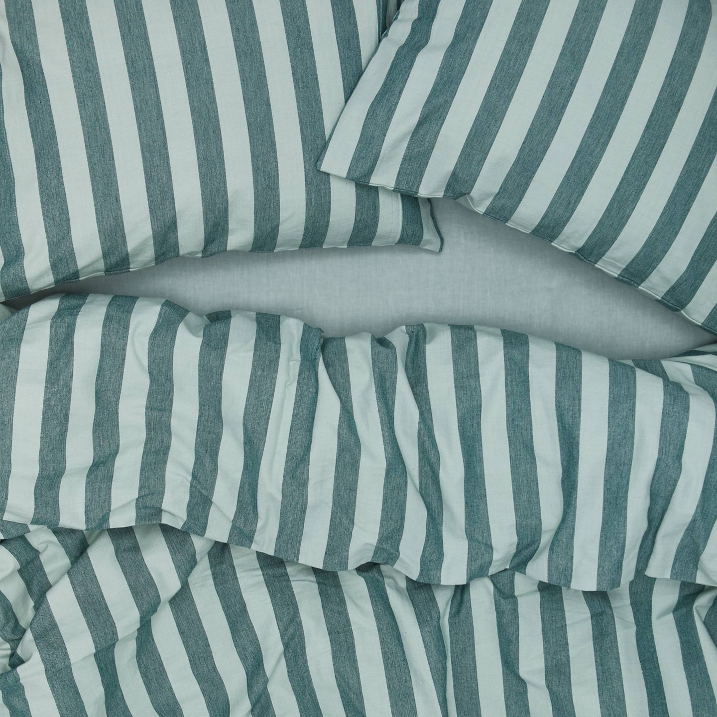 Essential Stripe Pillowcases, Set of 2 - Sky/Peacock on bed  with matching duvet