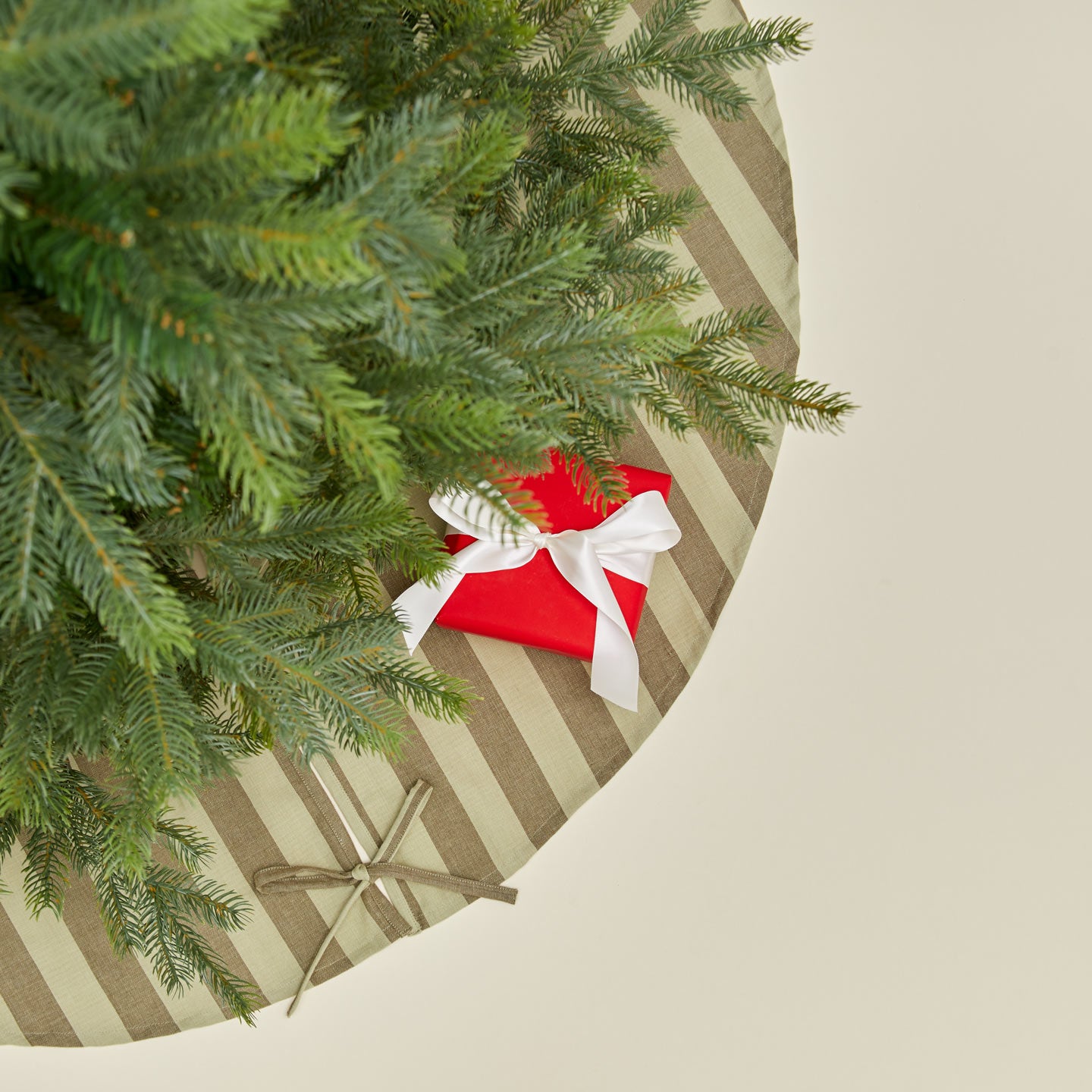 Overhead view of Essential Striped Tree Skirt - Olive/Sage with tree