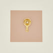Brass egg separator on a beige background