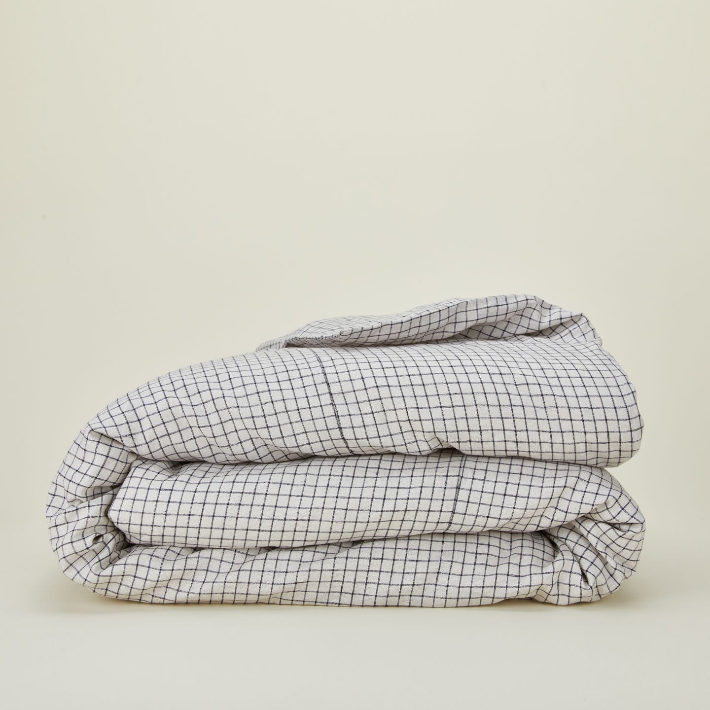 A folded checked linen duvet cover.