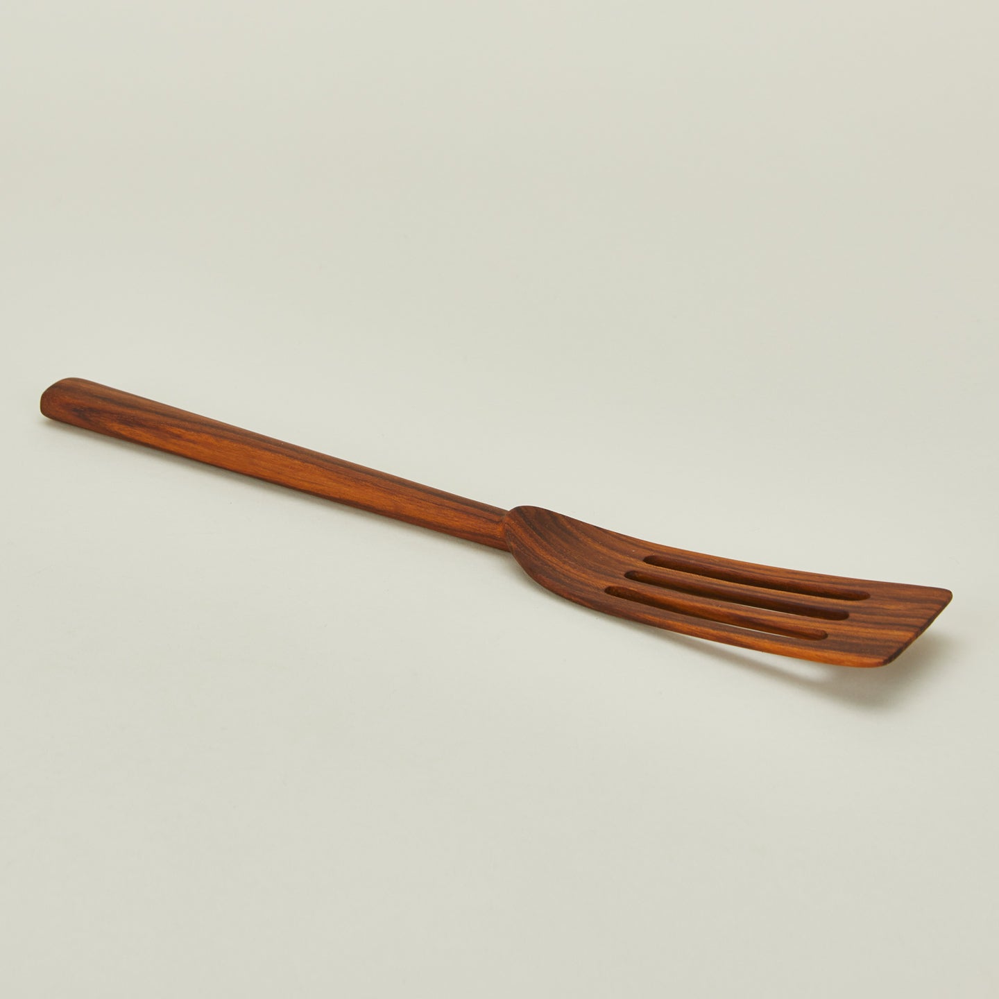 Detailed view of Narrow teak slotted spatula