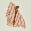 Narrow teak slotted spatula with kitchen towel