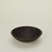 A close up  of a 12” ebonized oak  wood bowl.