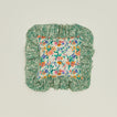 A ruffled floral cushion with a fern pattern.