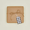 Buffalo plaid gift tag on box wrapped in craft paper