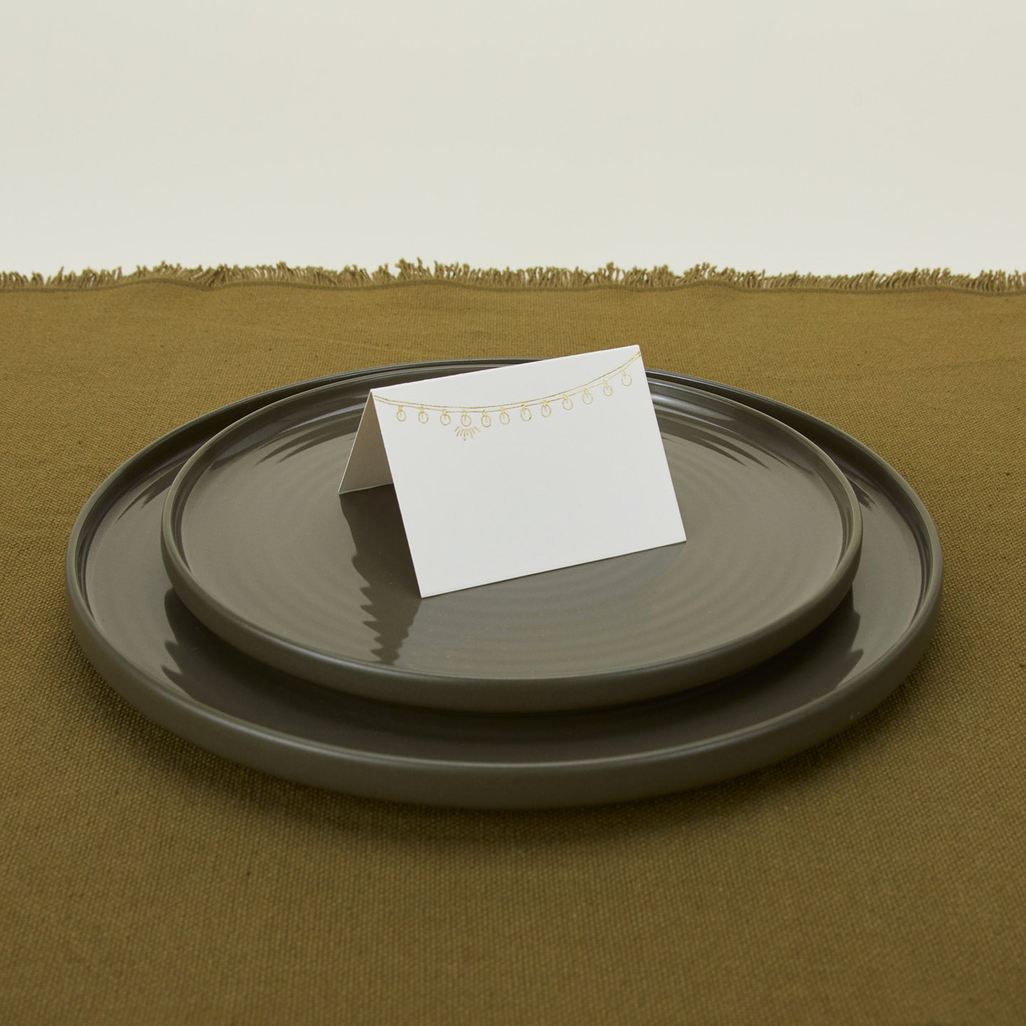 Foil pressed placecard lights on plate with a runner