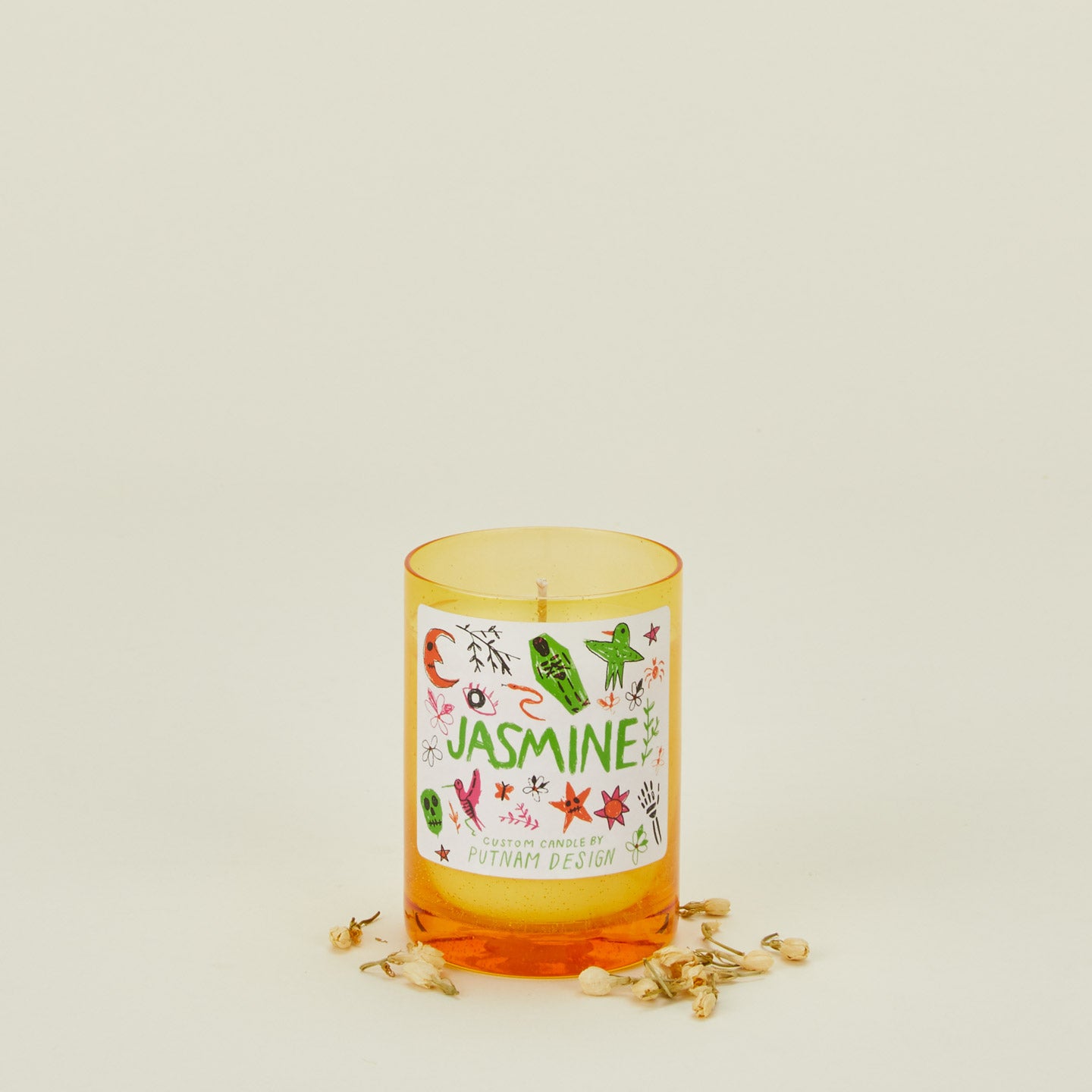 Candle with a decorative label on a light beige background