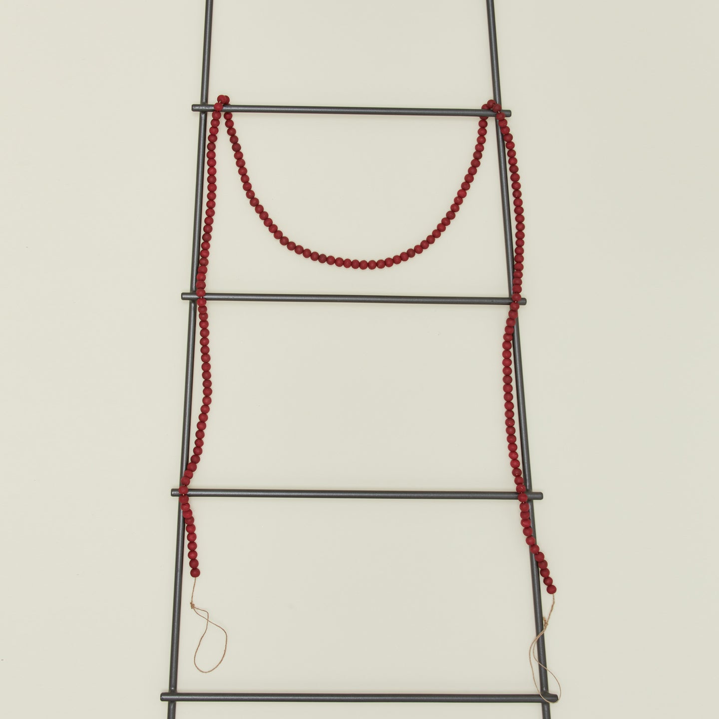 Wood beaded garland in red on ladder
