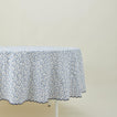 Little flowers round tablecloth in blue on table.