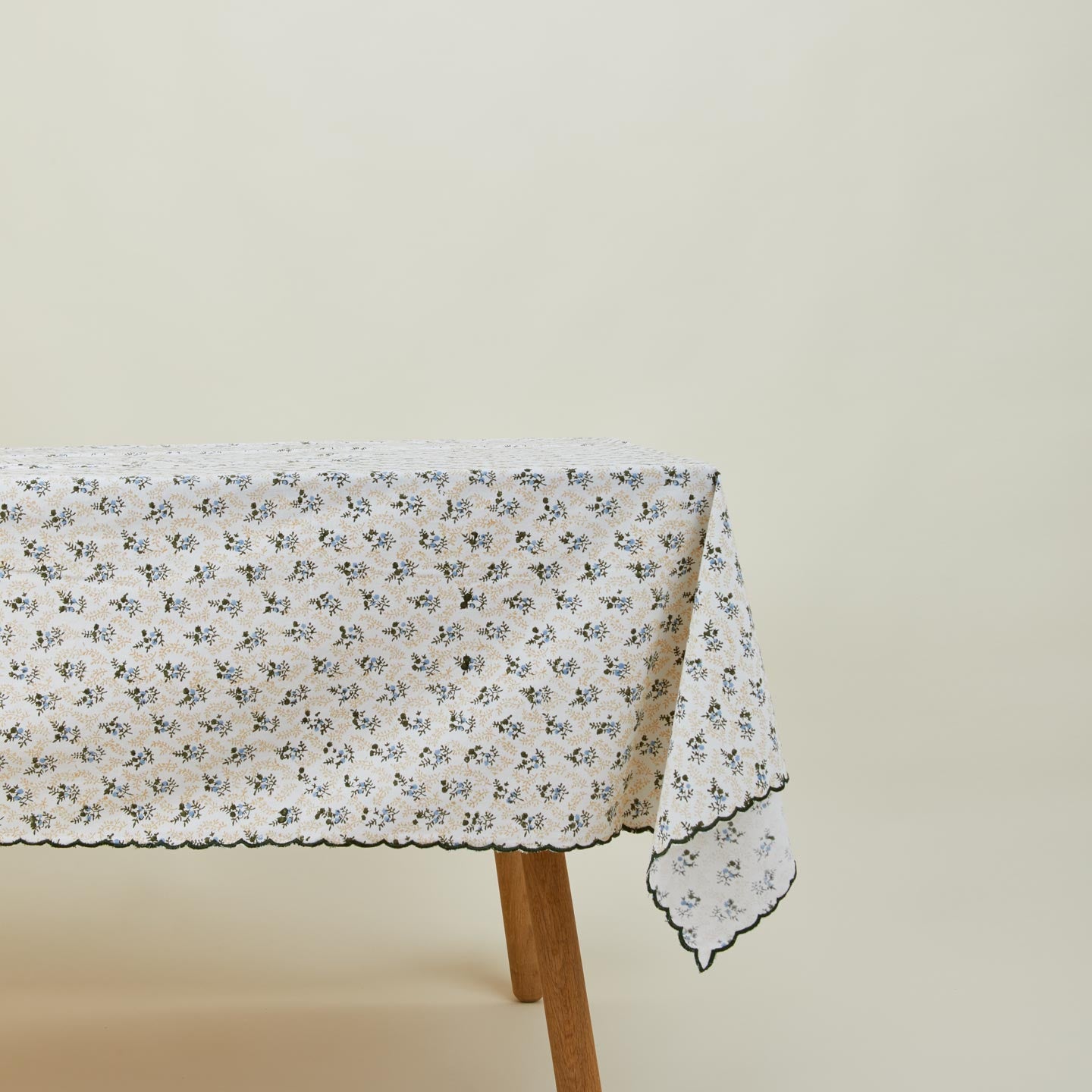 Little flowers rectangular tablecloth in green on table.