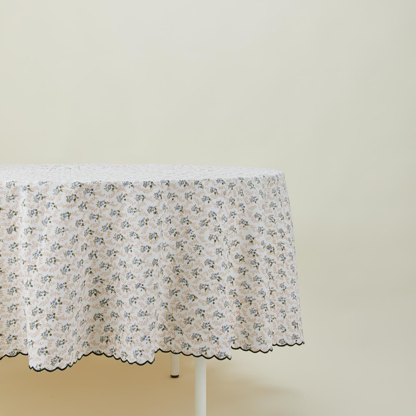 Little flowers round tablecloth in green on table.