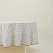 Little flowers round tablecloth in green on table.