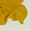 Detailed view of simple linen napkin in mustard