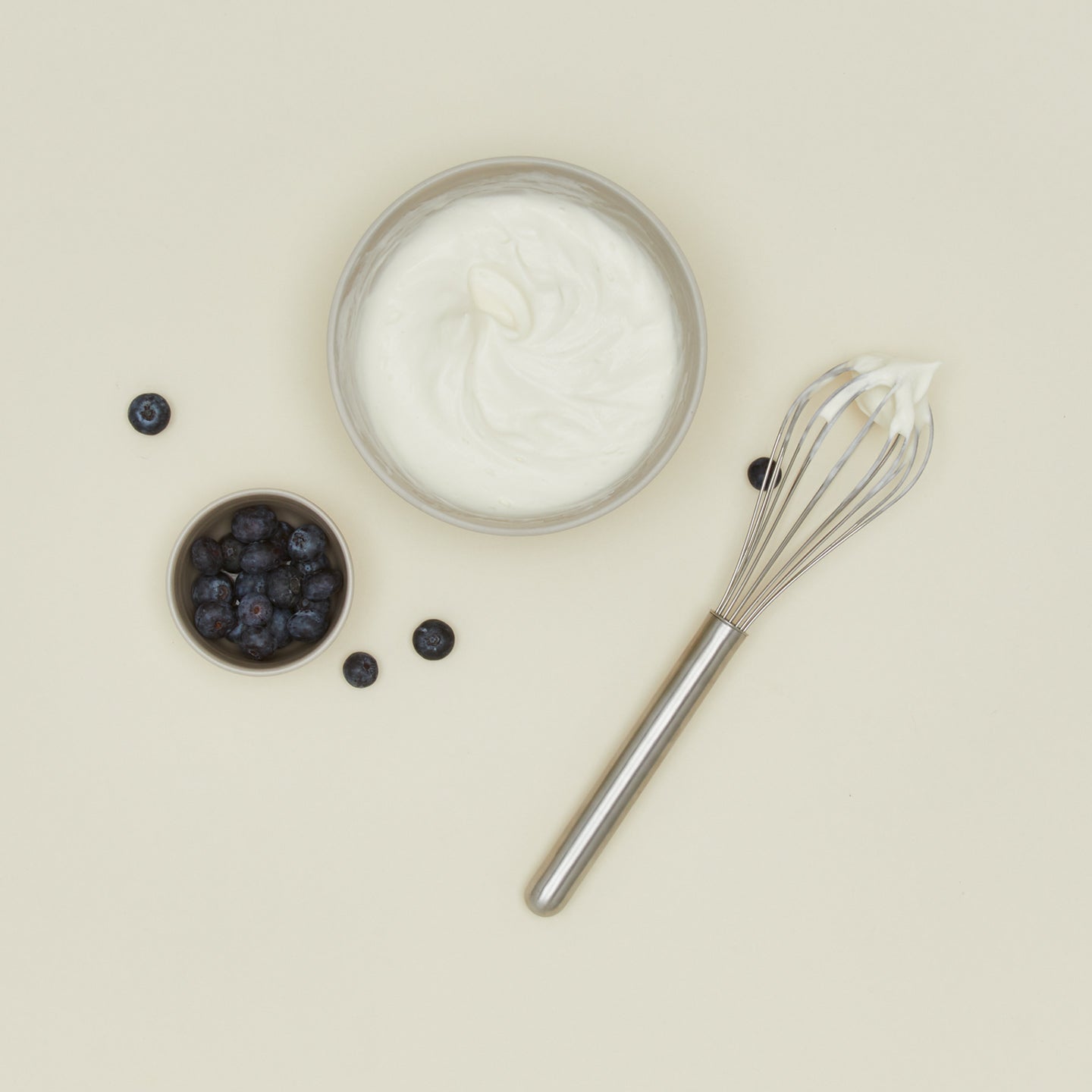 Simple metal whisk in silver with yogurt and blueberries