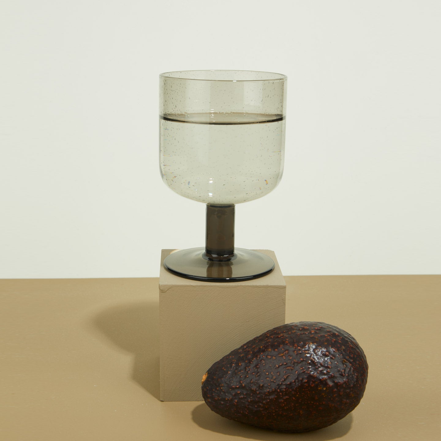 Simple Seeded Glass in Smoke on cube with avocado.