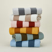 Stack of folded simple striped throws in various colors