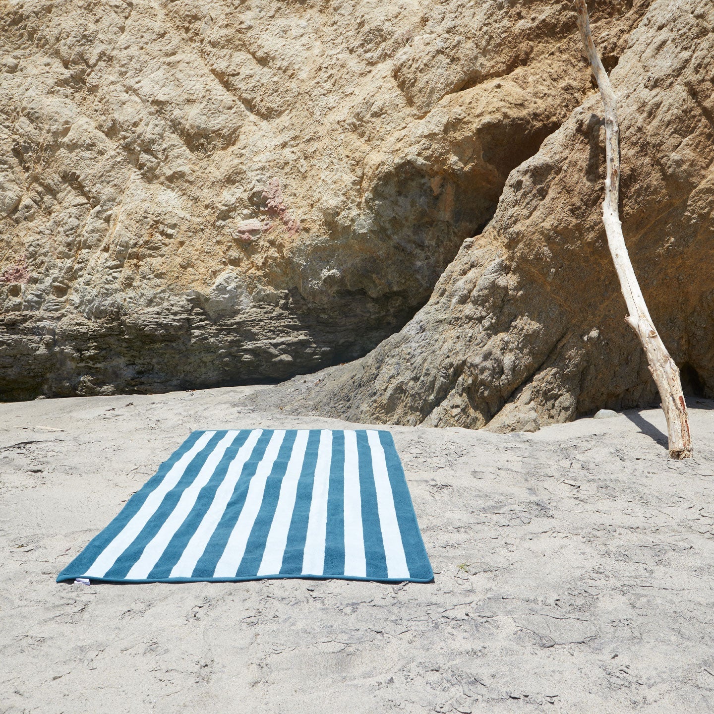 A striped sky and peacock terry towel at the beach.