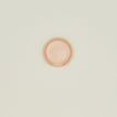 An overhead of a blush stoneware spoon rest.