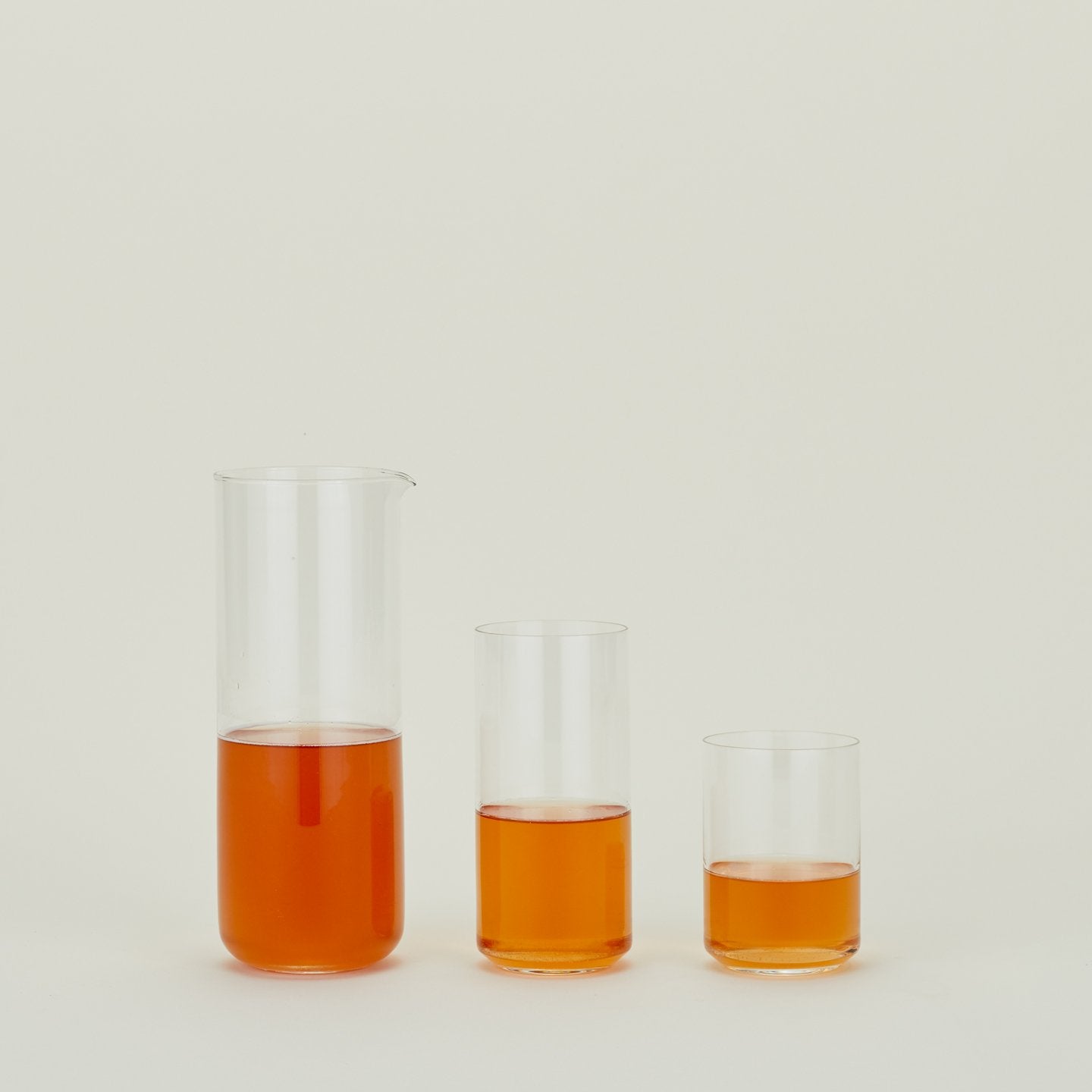 Simple Glass Pitcher and two Simple Glass Glasses filled with tea.