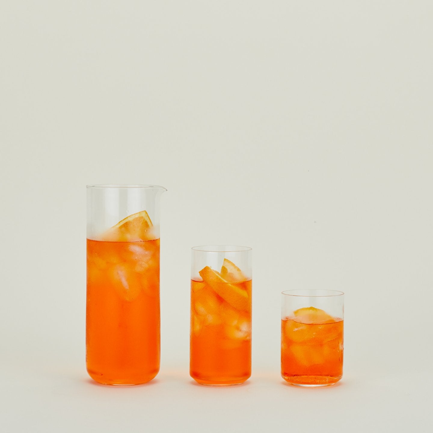 Simple Glass Pitcher and two Simple Glass Glasses filled with punch and fruit.