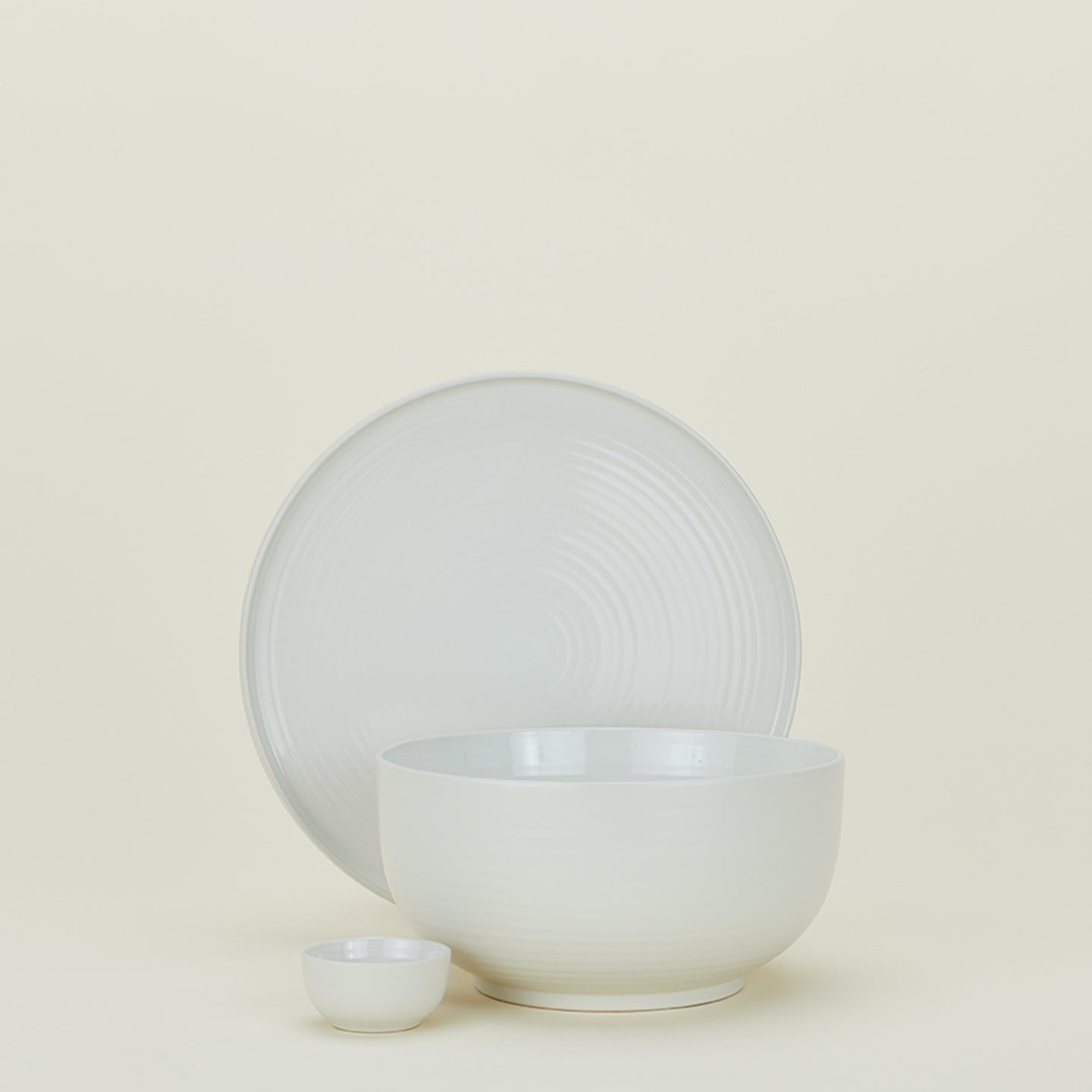 Group of Essential serving pieces in Bone including bowl, platter and extra small bowl.