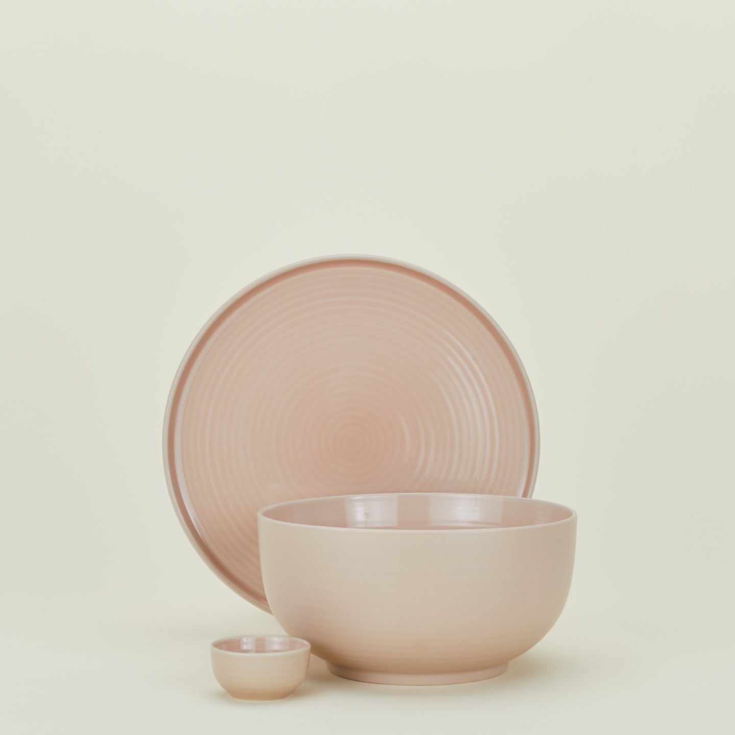 Group of Essential serving pieces in Blush including bowl, platter and extra small bowl.