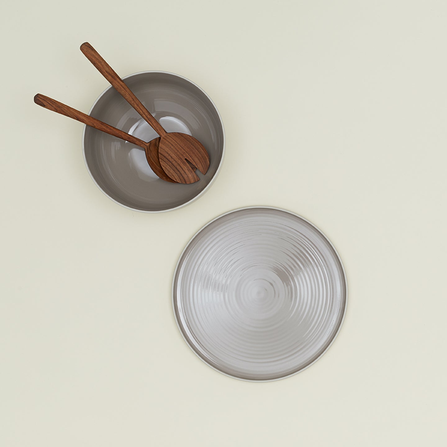 Essential Serving Platter and Serving Platter in Light Grey, with wood serving utensils.